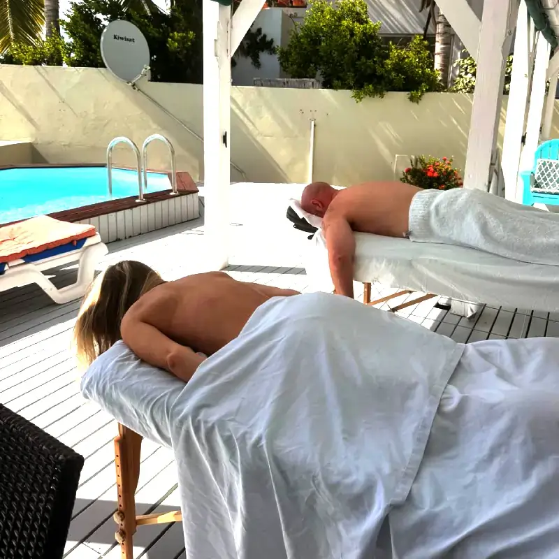 poolside-couple-massage Two people receiving massages beside a swimming pool